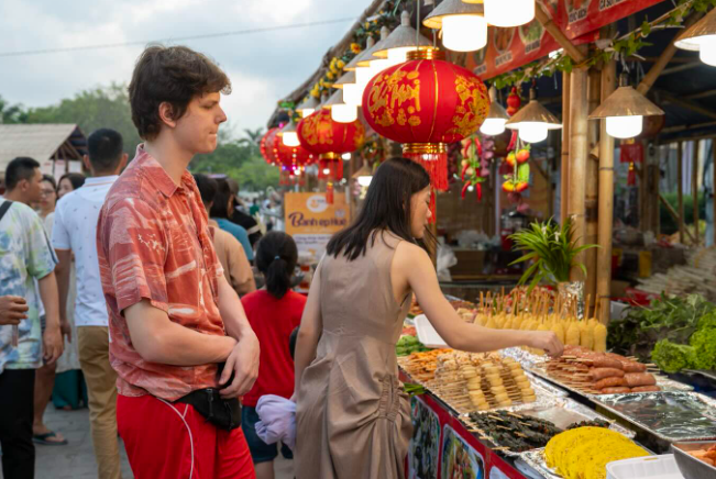 Du khách nước ngoài thưởng thức món ăn Huế trong không gian truyền thống.