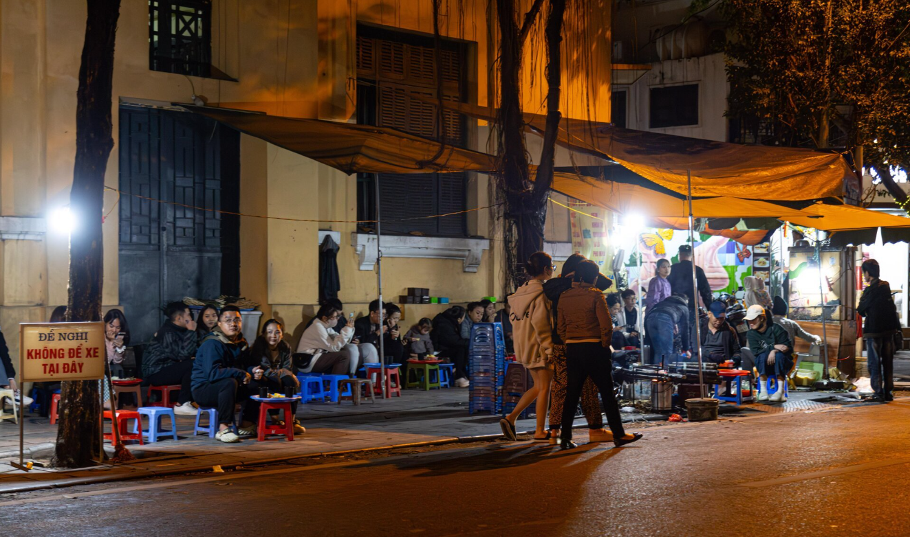 Nhóm bạn trẻ quây quần bên mâm ăn đêm vỉa hè Hà Nội.
