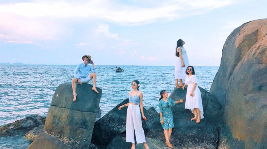 Du khách chụp ảnh bên ghềnh đá và mặt biển xanh thẳm ở bãi bụt Đà Nẵng.