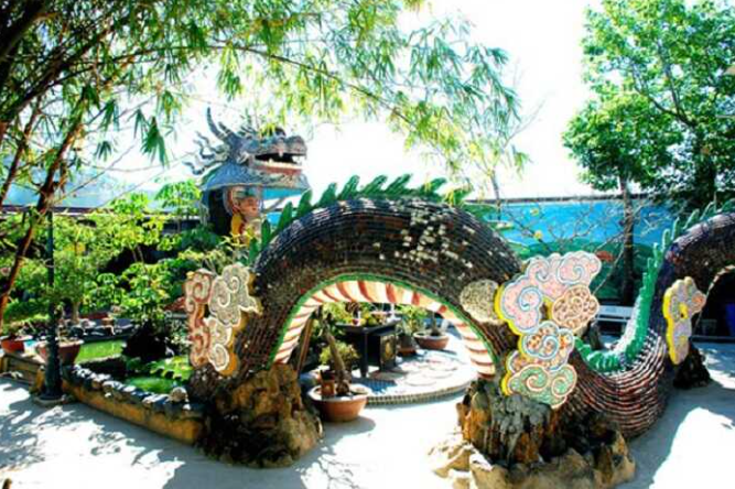 Con đường dẫn vào chùa Linh Phước với hàng thông xanh và cổng chùa uy nghi.