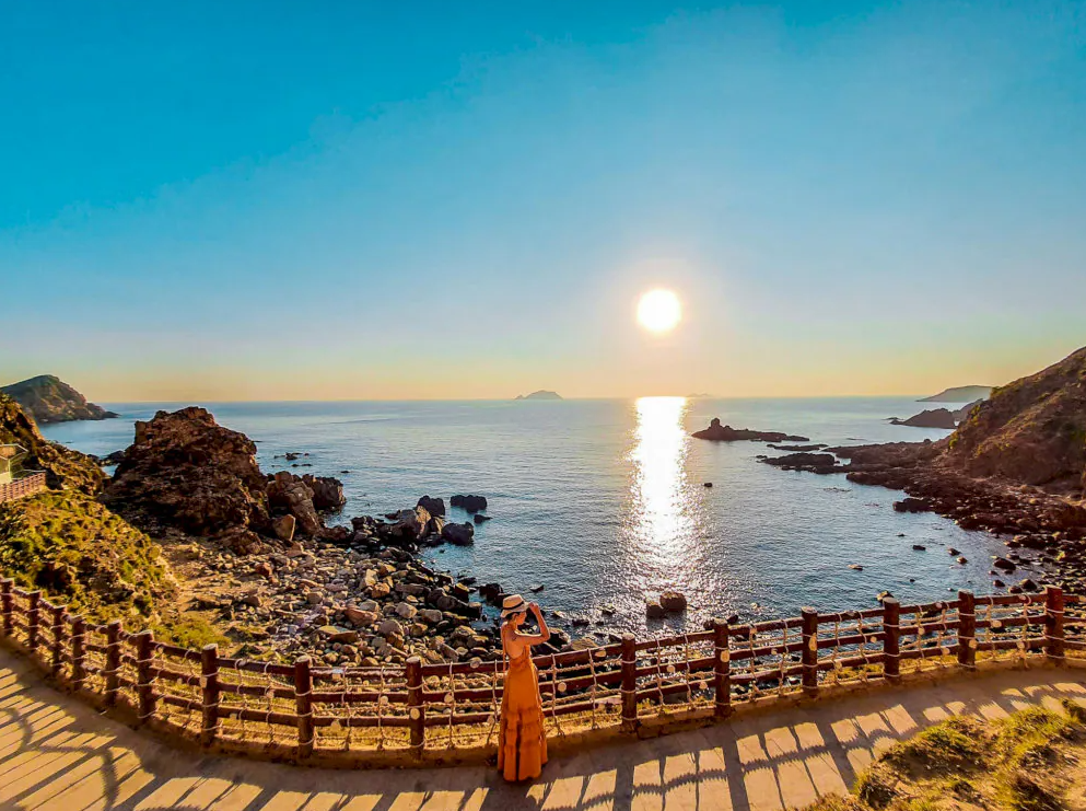 Bình minh rực rỡ trên mặt biển Eo Gió Kỳ Co, mặt nước phản chiếu ánh nắng vàng.