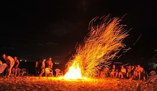 Nhóm bạn trẻ cắm trại, đốt lửa trại trên bãi biển Eo Gió Kỳ Co về đêm.