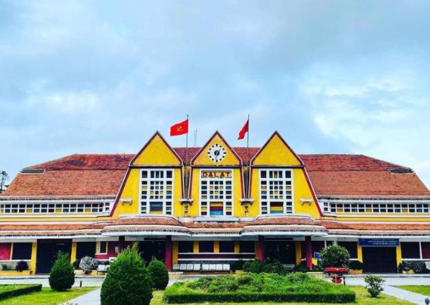 Biển hiệu ga Đà Lạt cổ điển với đồng hồ lớn treo trên mái tam giác.