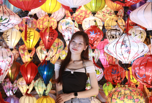 Du khách chụp ảnh tại khu đèn lồng nhiều màu sắc trong chợ đêm Helio Đà Nẵng.