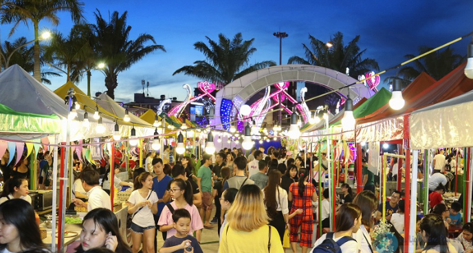 Khung cảnh Helio Đà Nẵng lúc hoàng hôn, đèn bắt đầu sáng, khách dạo quanh khu chợ đêm.