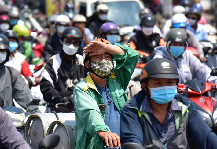 Hình ảnh người dân phải đội nắng gắt di chuyển giữa thành phố ngột ngạt.