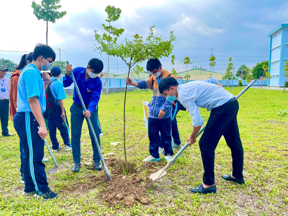 Hình ảnh nhóm học sinh trồng cây xanh trong công viên.
