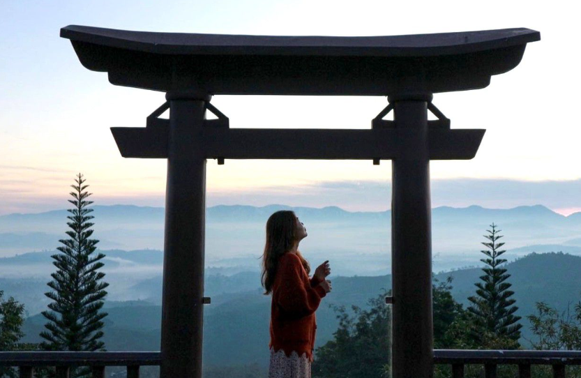 Du khách đứng trước cổng trời Linh Quy Pháp Ấn, phía sau là biển mây trắng xóa.