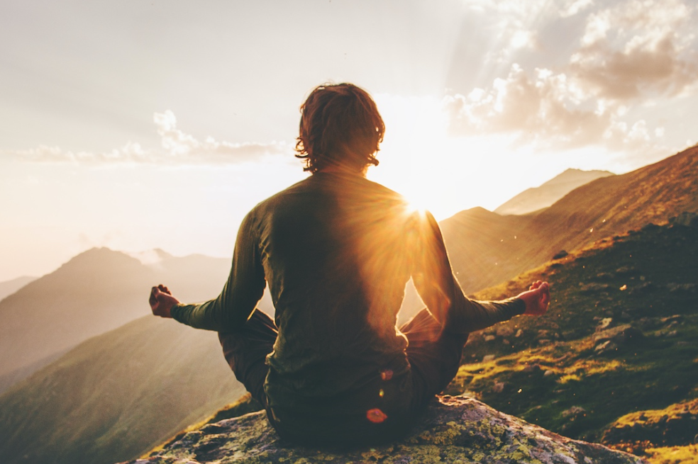 Bức tranh bình minh với người ngồi thiền hướng về phía mặt trời mọc, biểu trưng cho sự tĩnh tâm và khởi đầu mới.