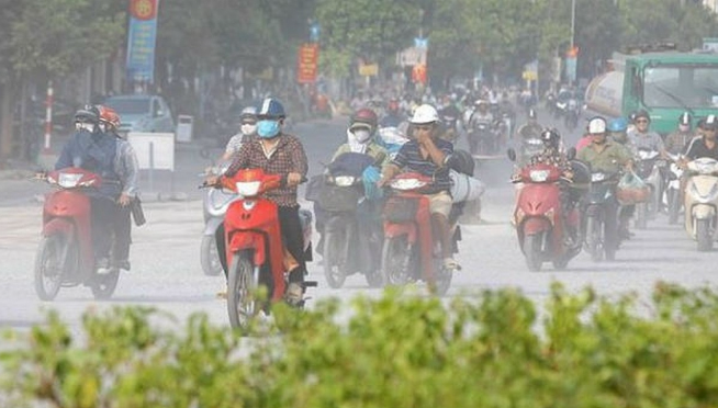 Người dân che ô và đeo khẩu trang khi di chuyển trong cơn mưa ô nhiễm tại đô thị.