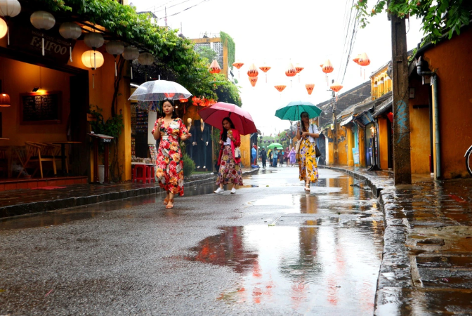 Cảnh Hội An trong cơn mưa nhẹ tháng 12, người dân che ô đi dọc phố cổ.