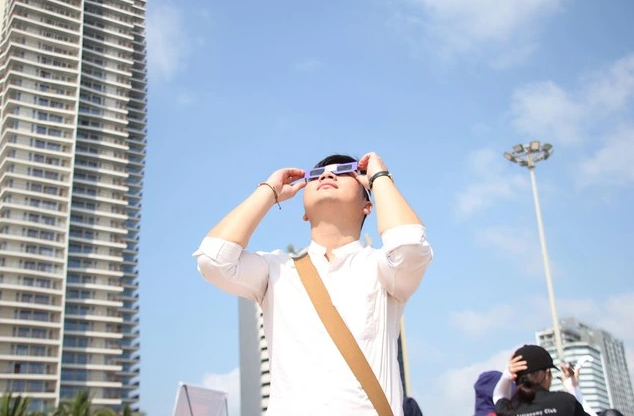 Người dân dùng kính bảo vệ mắt khi quan sát nhật thực trên đường phố.