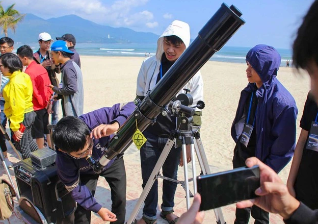 Người dân Việt Nam xếp hàng quan sát nhật thực bằng kính đen trong buổi sáng năm 2009.