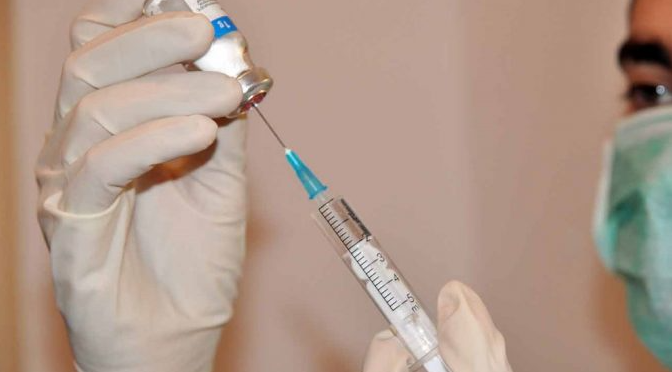  Y tá đang pha thuốc tiêm bằng nước cất trong phòng vô trùng.