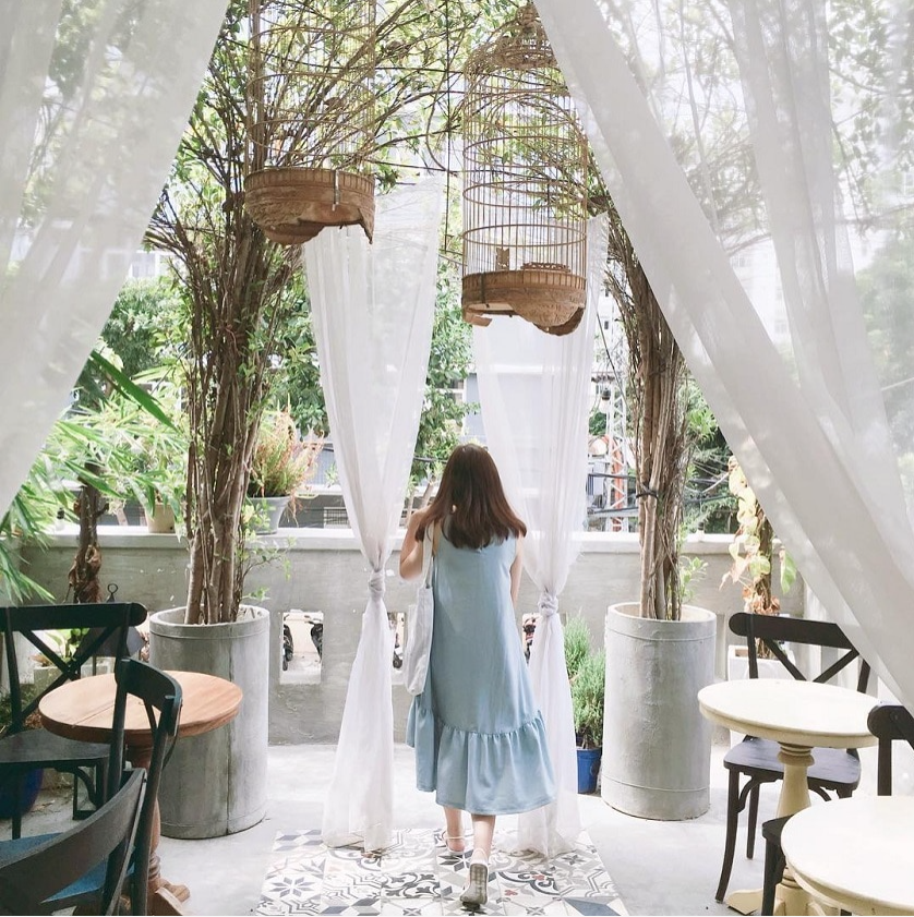 Quán cà phê tone trắng, decor Hàn Quốc, khách chụp ảnh selfie trong ánh sáng tự nhiên.