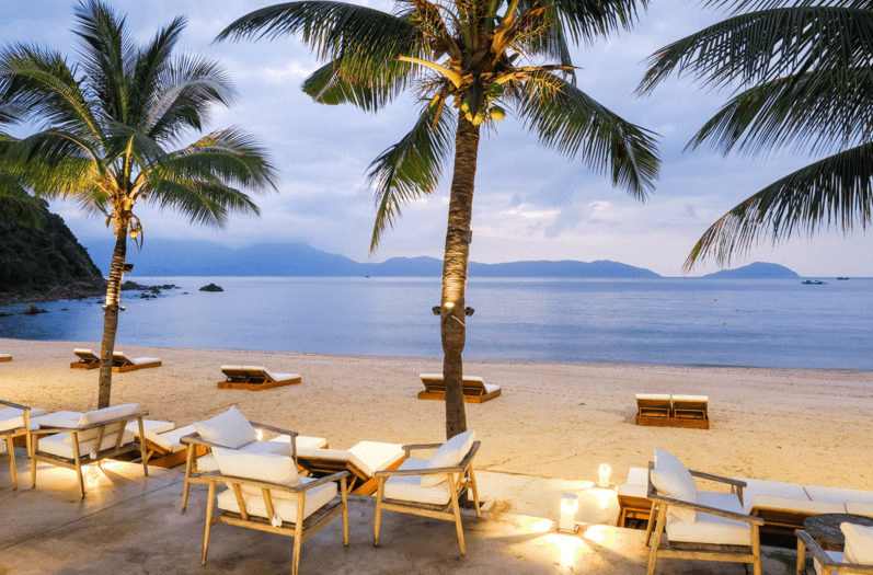 Quán cà phê ven biển Mỹ Khê, khách ngồi ngắm bình minh, ánh sáng vàng chiếu trên mặt biển.