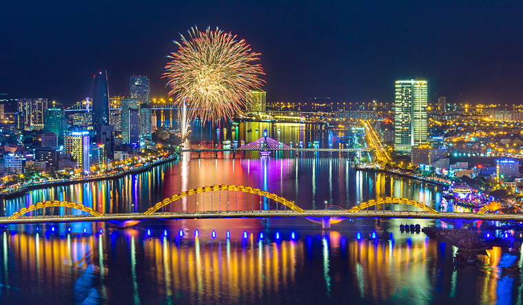  Cầu Rồng Đà Nẵng lung linh trong đêm mùa đông, phản chiếu ánh sáng xuống mặt nước sông Hàn.