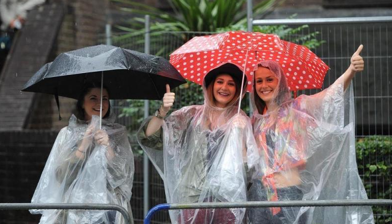 Du khách mặc áo mưa nhẹ đi dạo phố trong cơn mưa phùn Đà Nẵng.